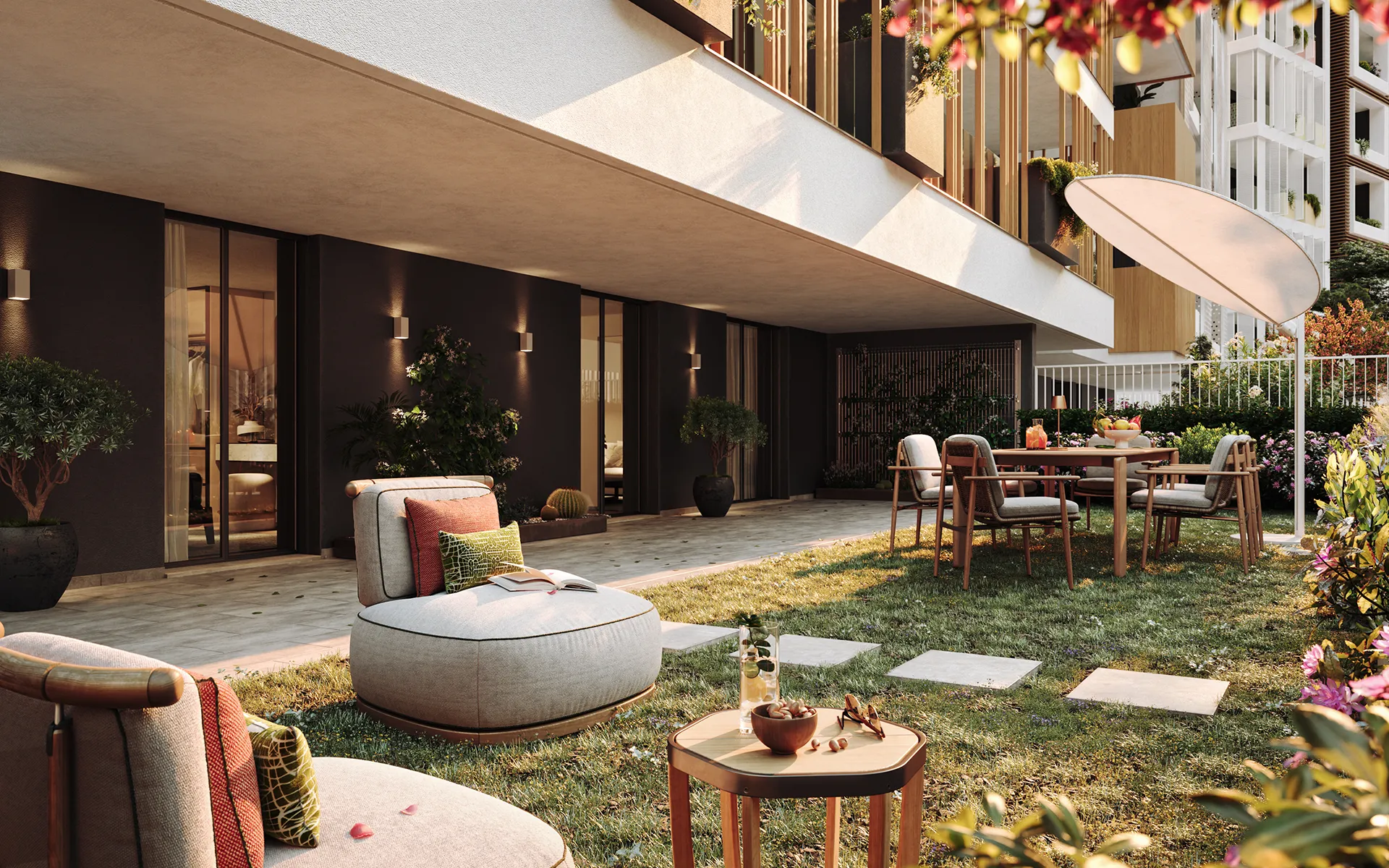 Giardino curato di un appartamento moderno con salottino all’aperto, tavolo da pranzo, ombrellone e vegetazione rigogliosa, ideale per il relax e la convivialità